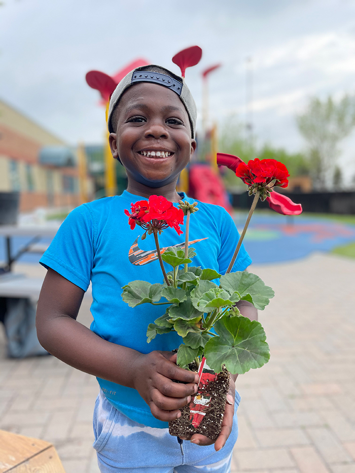 Kid Planting Flowers at SCA Preschool